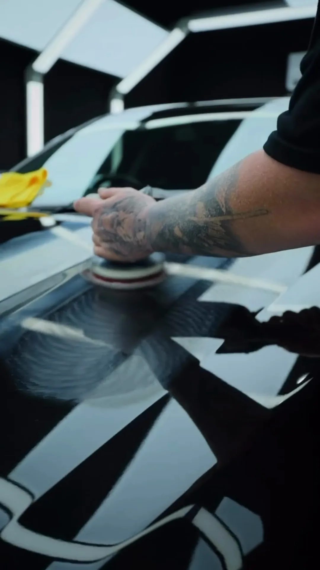 Machine polisher working across a black bonnet