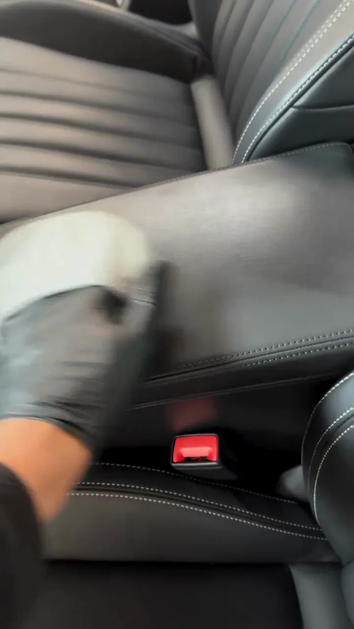 Leather armrest being wiped down by hand